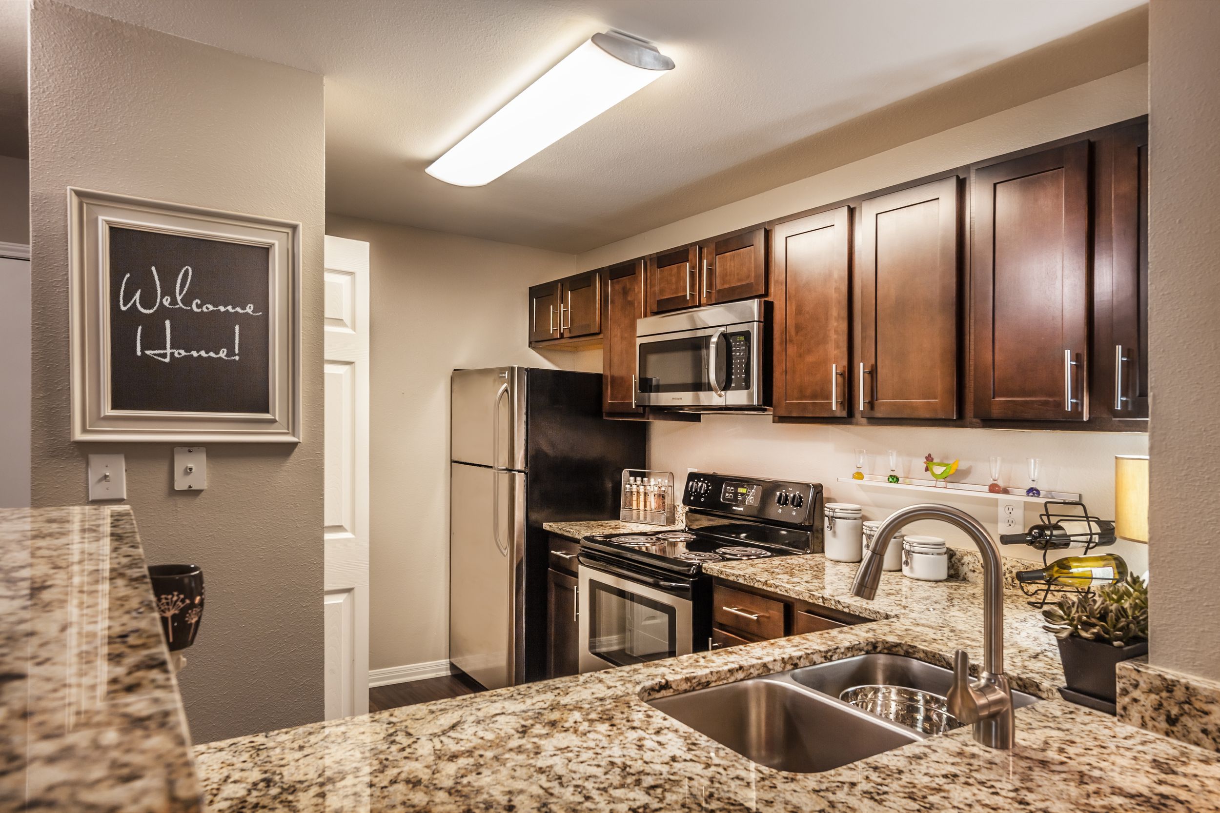 Spacious kitchen with granite counter tops, dark wood cabinetry, and stainless steel appliances