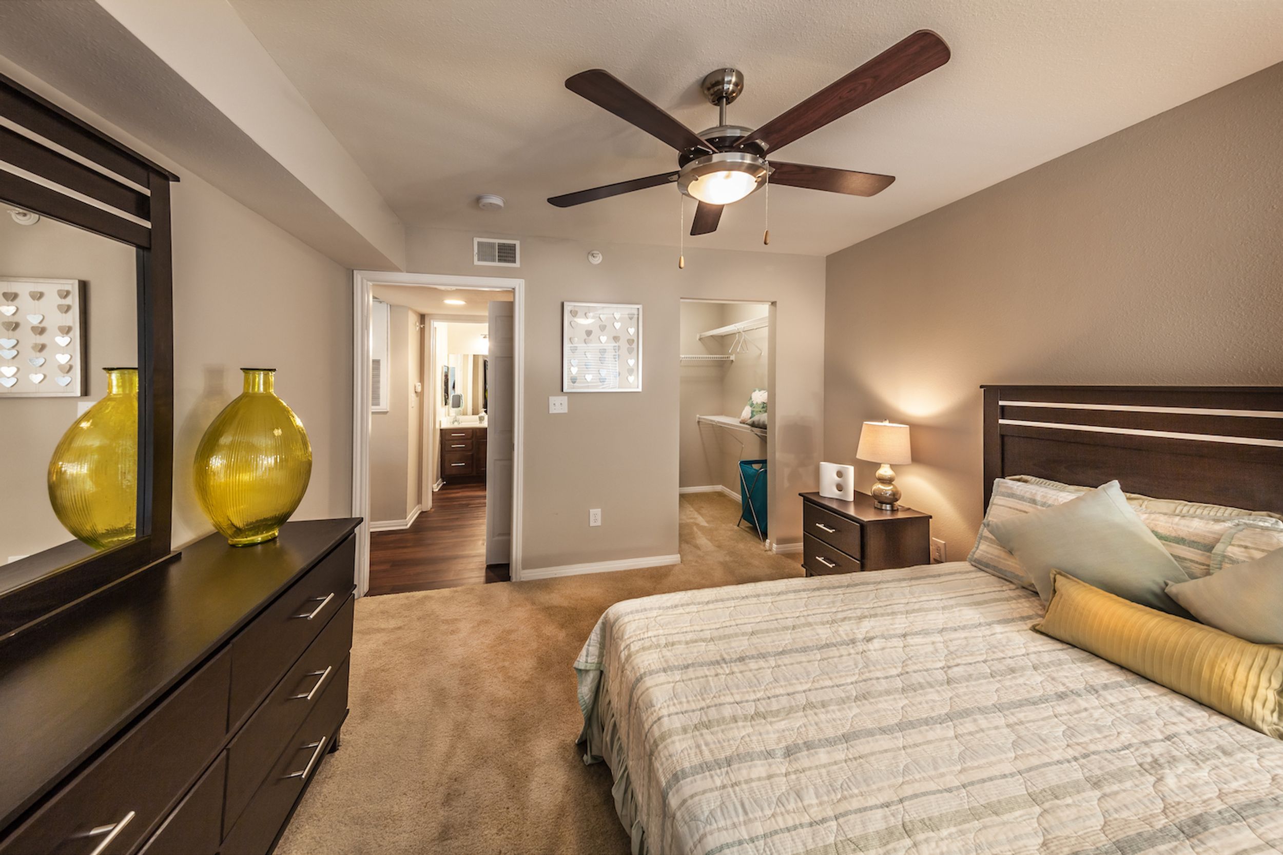 large bedroom with earth tones and dark wood furnishings