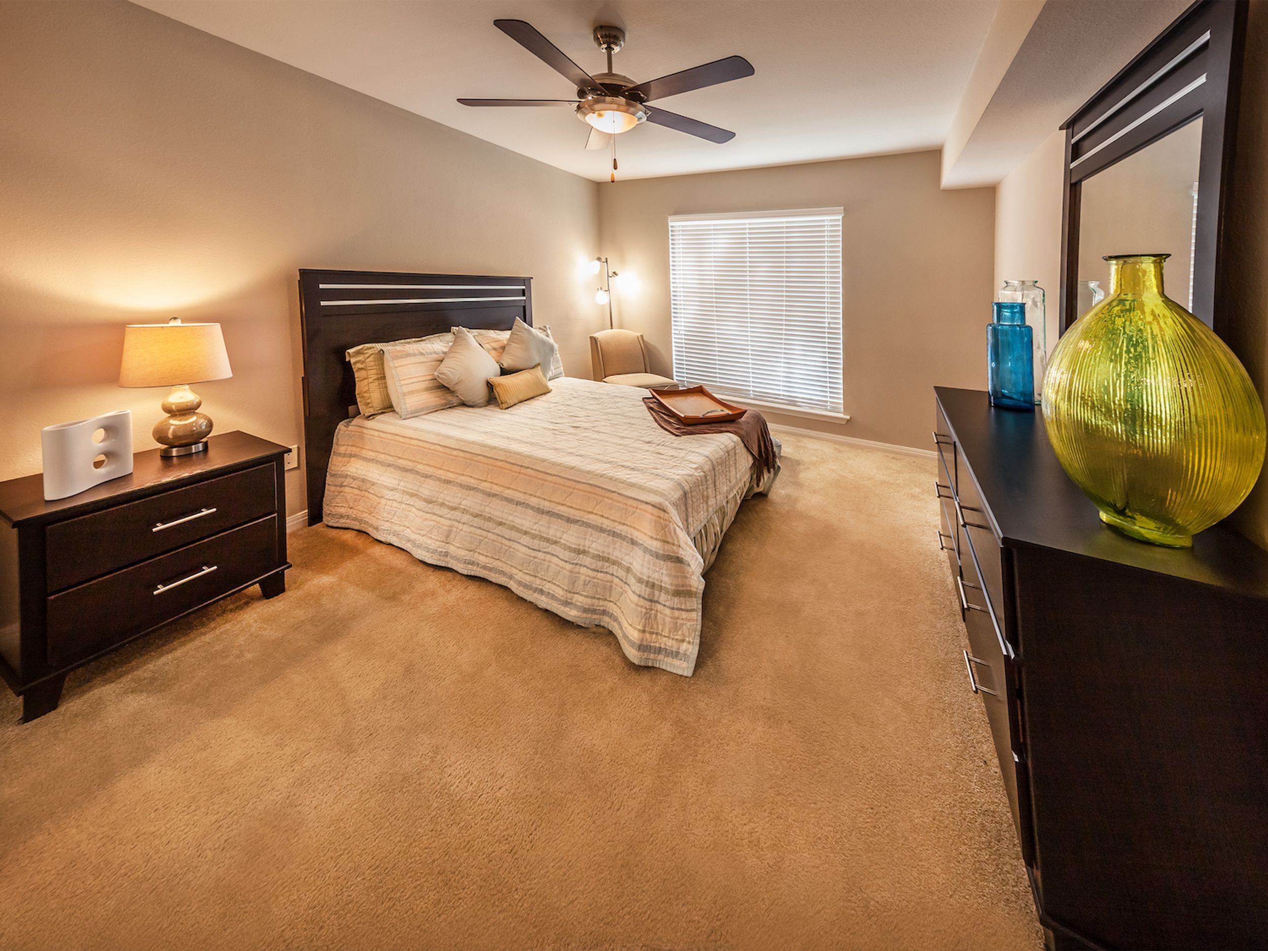 Bedroom with earth tone color scheme, walk in closet and bathroom