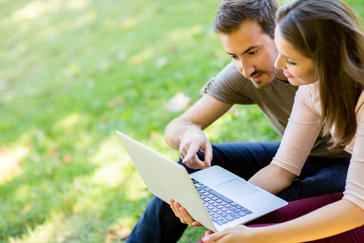 man and woman reading on laptop