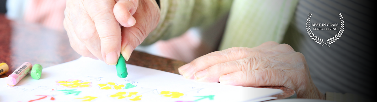 senior hands drawing with colorful chalk
