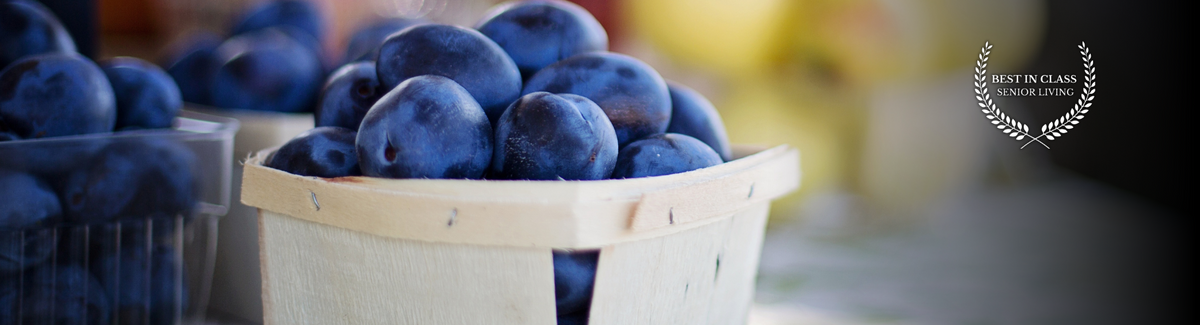 pint of plums at a farmers market