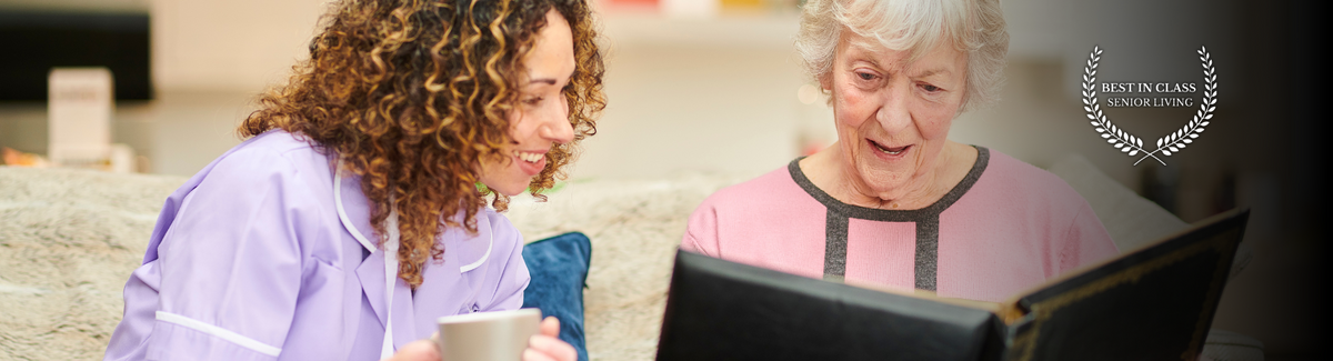 caregiver and senior looking at memory book