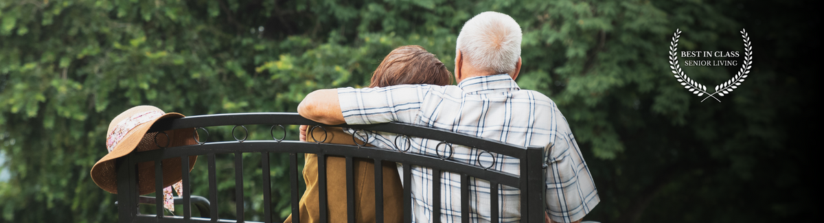 seniors hugging sitting on a park bench