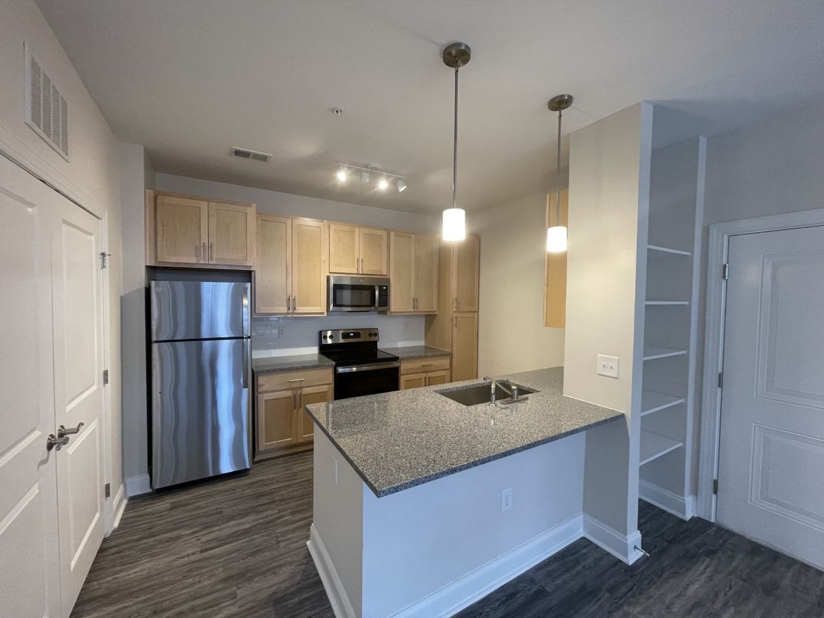 1 Bed 1 Bath Kitchen with counter seating and built in storage. 